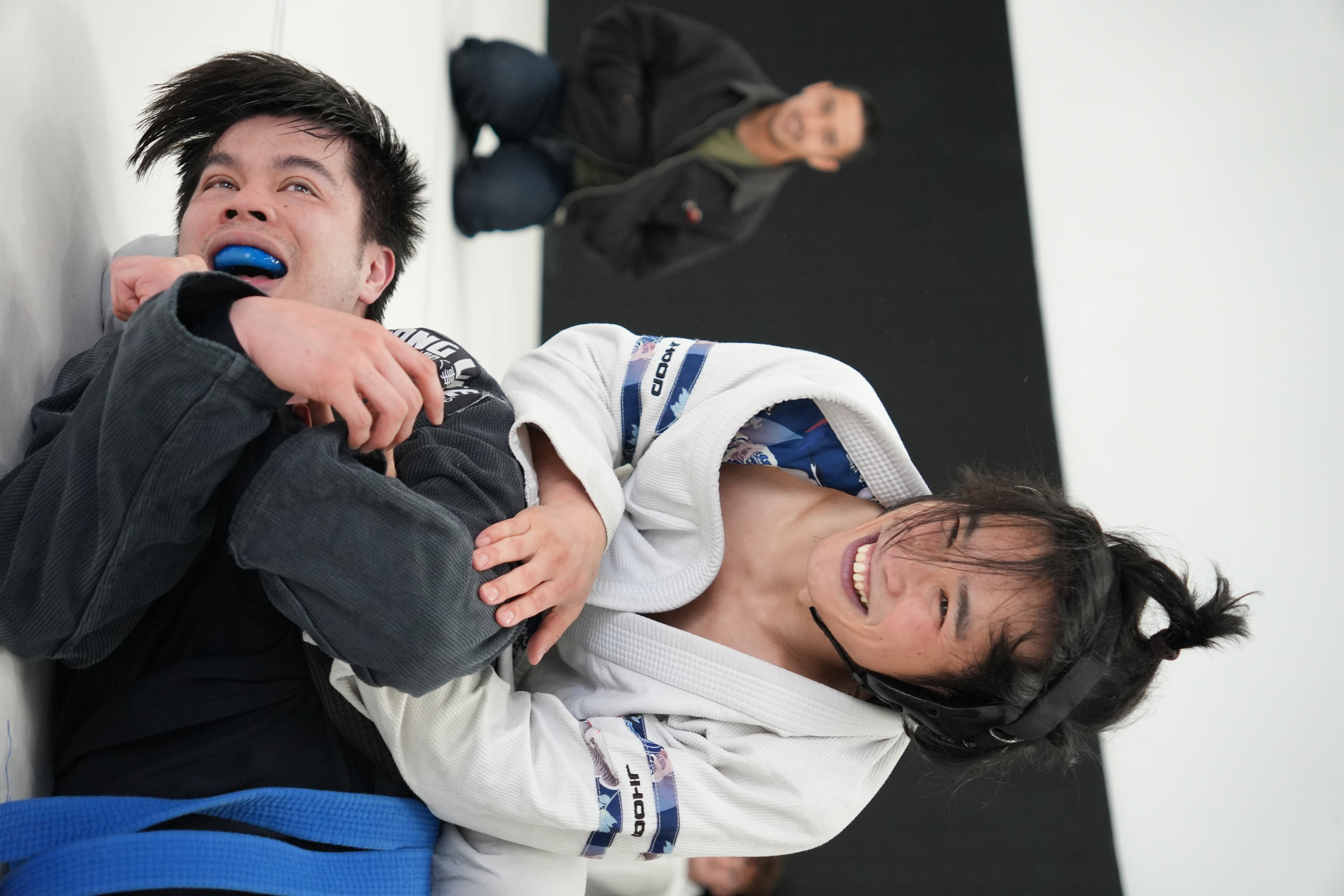 A coach happily training with students at First Page Grappling